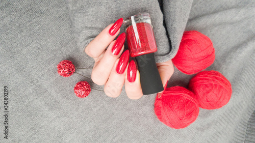 Εκτύπωση καμβά Female hand with long nails and a bottle bright red color nail polish