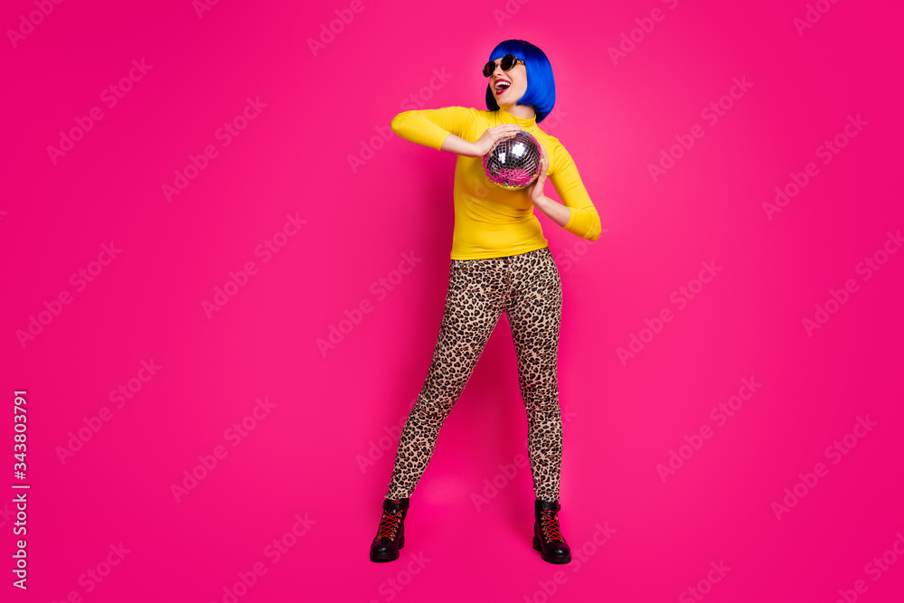 Full body photo of crazy clubber lady youth student costume party hold disco ball wear specs yellow turtleneck blue bob wig boots leopard pants isolated vibrant pink color background Full body photo of crazy clubber lady youth student costume party hold disco ball wear specs yellow turtleneck blue bob wig boots leopard pants isolated vibrant pink color background