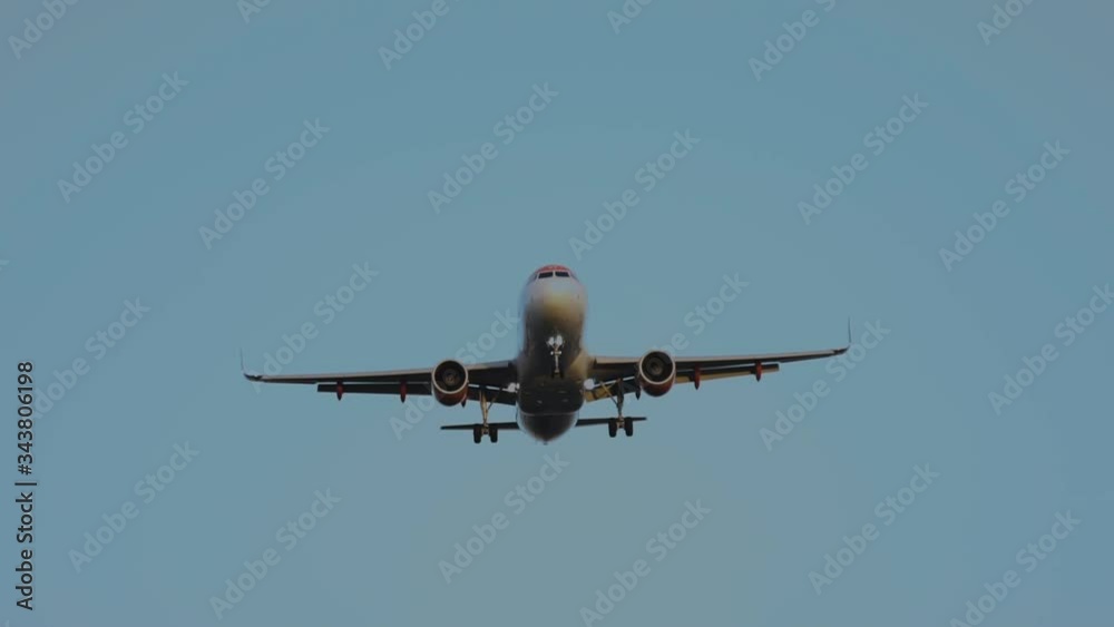 Avión se dispone a aterrizar bajo un cielo azul sin nubes.