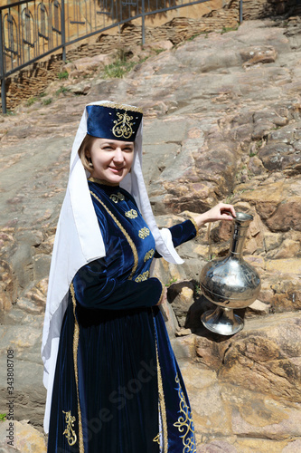 Tourist woman with jug in Karachai clothes photo