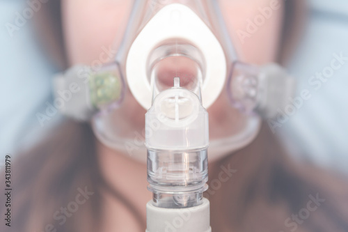 oxygen mask on the girl's face. resuscitation concept. treatment of respiratory failure and respiratory syndrome.