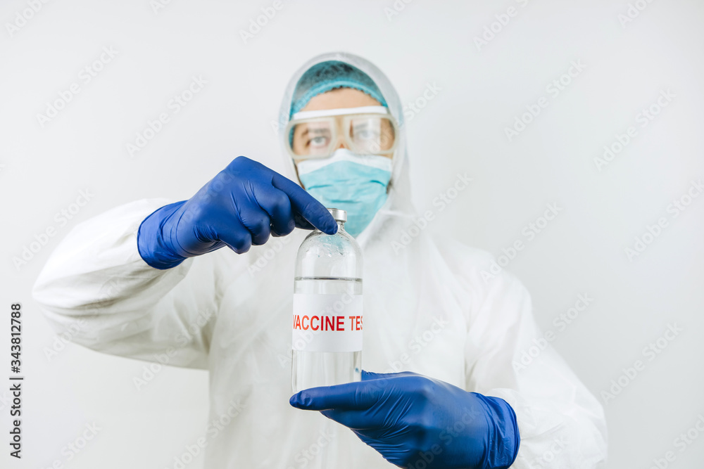 A doctor in a white coat and blue gloves holds a test tube with a coronavirus vaccine. Covid 2019 vaccine injection. 2020 pandemic coronavirus. Vaccine test. A doctor in a white coat and blue gloves holds a test tube with a coronavirus vaccine. Covid 2019 vaccine injection. 2020 pandemic coronavirus. Vaccine test.