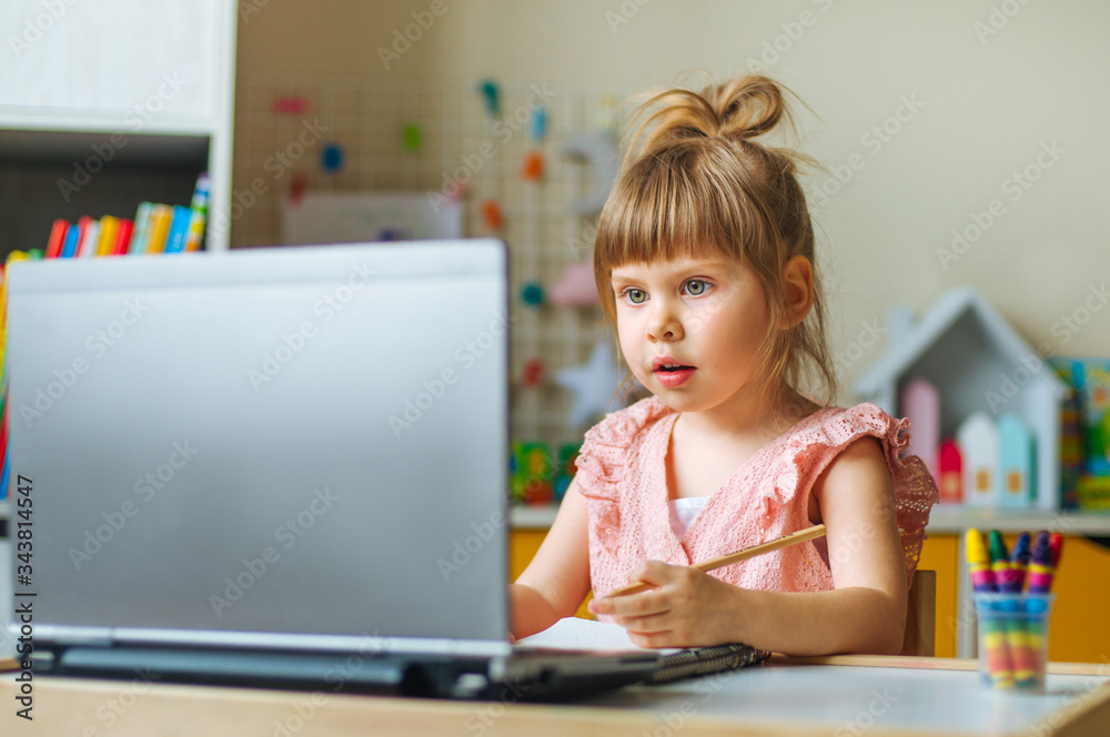 Little girl using the notebook for distance learning Little girl using the notebook for distance learning