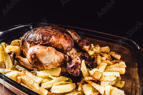 delicioso pollo al horno con patatas fritas. asilado en fondo negro