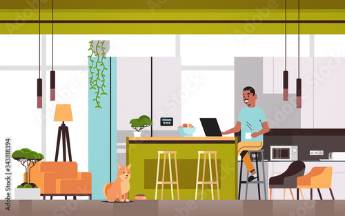 african american man freelancer using laptop working at home during coronavirus quarantine self-isolation social distancing concept modern kitchen interior horizontal full length vector illustration