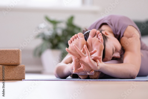 Calm spiritualized young woman yoga instructor meditates in the pose of madha mudra. Concept of the disclosure of energy channels and home yoga sessions. Advertising space photo