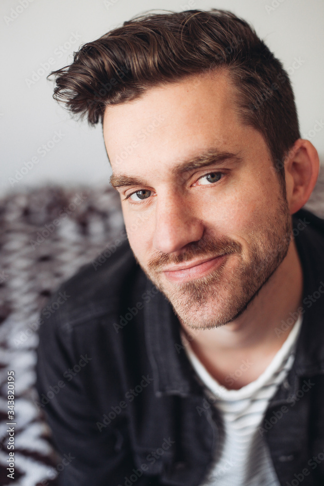 A portrait of a young handsome man charming smile, indoors A portrait of a young handsome man charming smile, indoors
