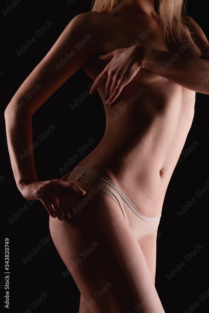 Beautiful young girl body on a dark background, the concept of a healthy, slim and well-groomed body Happy family together with a dog lie on a large bed indoors.