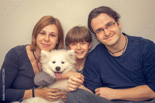 Happy family with dog posing for photo inside the house.