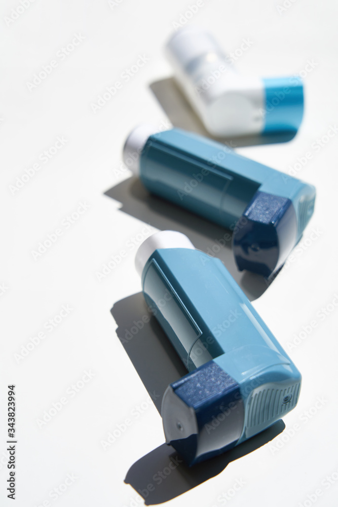 Many Asthma inhalers lying on white background Many Asthma inhalers lying on white background