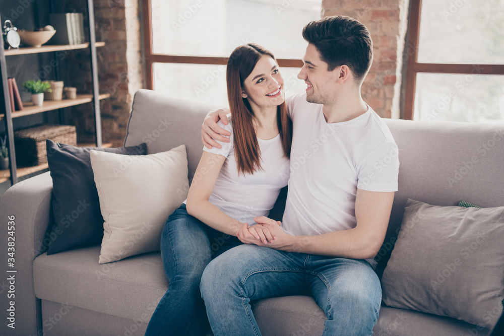 Portrait of her she his he nice attractive lovely cheerful dreamy sweet couple sitting on divan enjoying at modern industrial loft style brick interior living-room flat indoors