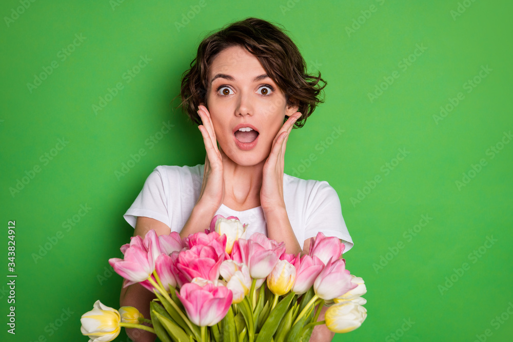 Clloseup photo of beautiful cute lady wavy hairdo receiving large big tulips surprise bunch present secret admirer delivery service wear casual white t-shirt isolated green color background