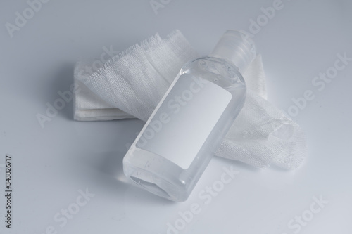 White medical cotton gauze bandage and antiseptic gel lay on white, gray background, Medical bandage of new first aid gauze unrolling