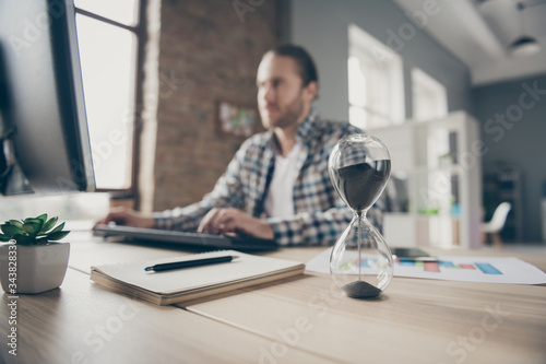 Foto Blurry focus photo of handsome business guy look computer monitor sand clock on