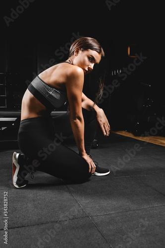 Fitness model posing in the fitness room. Fitness motivation concept, beautiful body, success achievement. Copy space, sports banner.