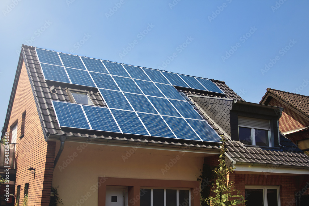 Rooftop of house with solar panel system installed. Sun electricity. Efficient way of getting energy for electricity and water heating.Green energy for living. Environment saving solution. Rooftop of house with solar panel system installed. Sun electricity. Efficient way of getting energy for electricity and water heating.Green energy for living. Environment saving solution.