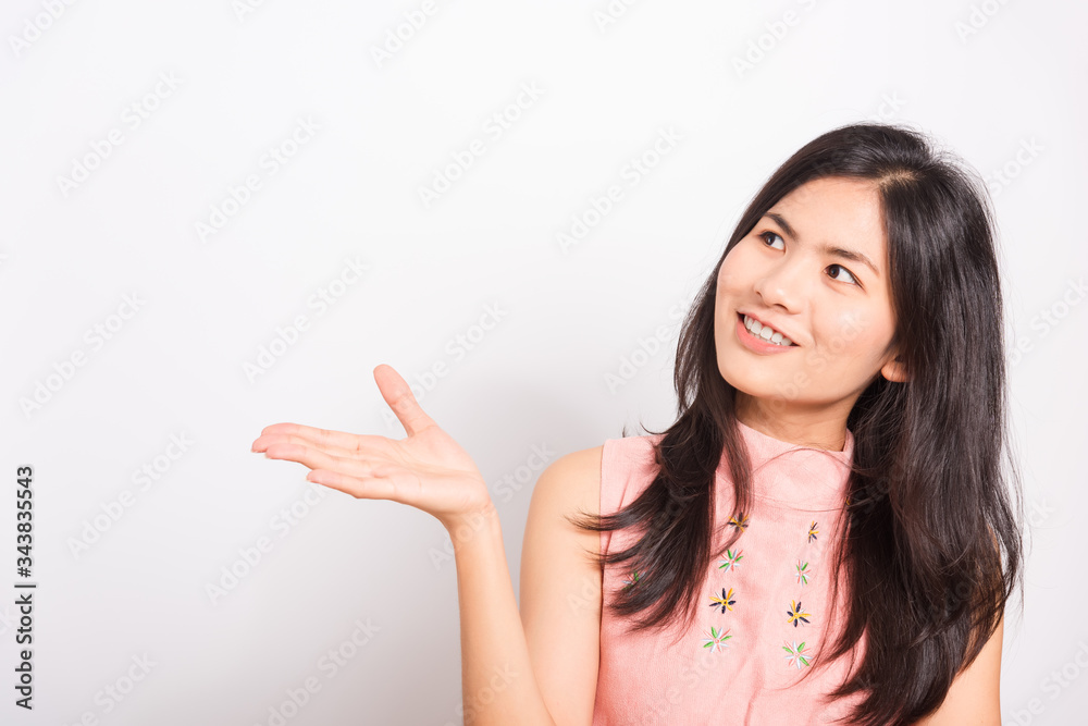 Portrait Asian beautiful young woman standing, She showing hand to presenting product and looking to product, shoot photo in a studio on white background, There was copy space Portrait Asian beautiful young woman standing, She showing hand to presenting product and looking to product, shoot photo in a studio on white background, There was copy space