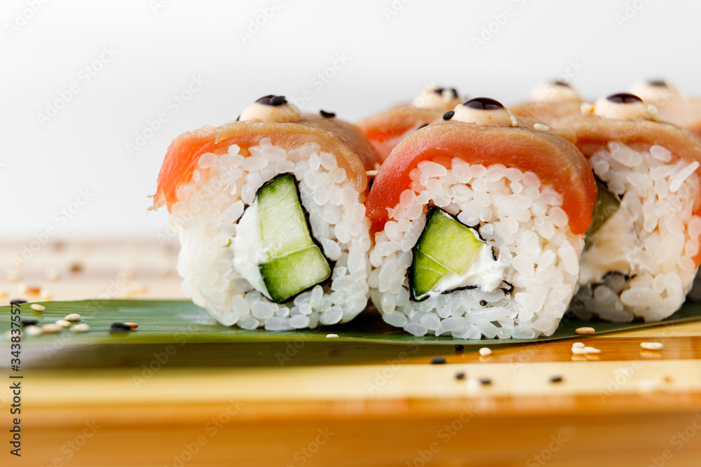 Maki Sushi Rolls set on wooden bamboo board. Japanese traditional Cuisine. White background. Maki Sushi Rolls set on wooden bamboo board. Japanese traditional Cuisine. White background.