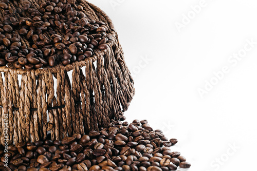 Coffee beans laid out on a white background with a basket