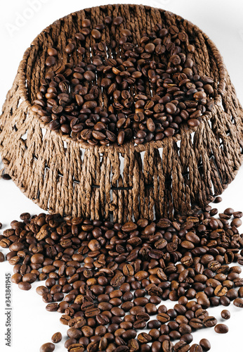 Coffee beans laid out on a white background with a basket