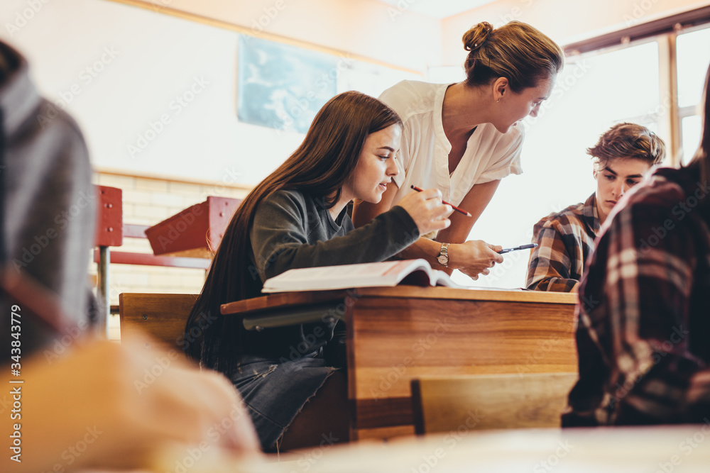 Professor helping students during a class at high school Professor helping students during a class at high school