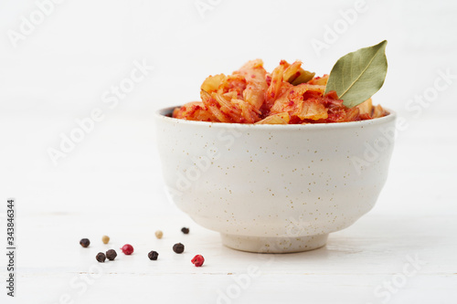 Kimchi. Fermented Chinese cabbage in a bowl on a white background. Korean food. Copy space. Fermented and vegetarian preserved food concept.