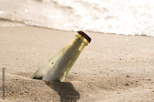 Messaggio in piccola bottiglia dal tappo rosso rovinato dal mare