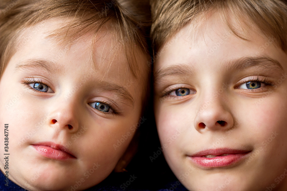 Two faces closeup portrait boy and girl brother and sister, beautiful cute children look straight with blue eyes Two faces closeup portrait boy and girl brother and sister, beautiful cute children look straight with blue eyes