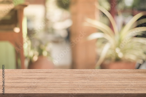 Empty of wood table top with blurred coffee shop on background