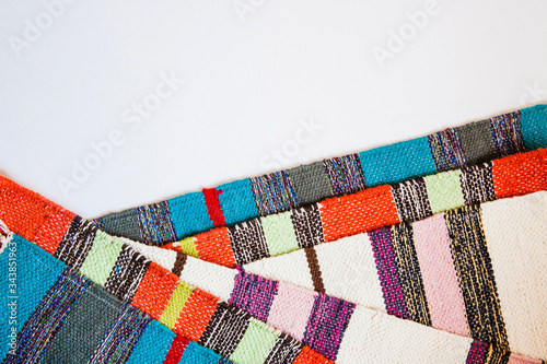 Several brightly colored striped textile mats on a white background. Colorful textile texture with space for text