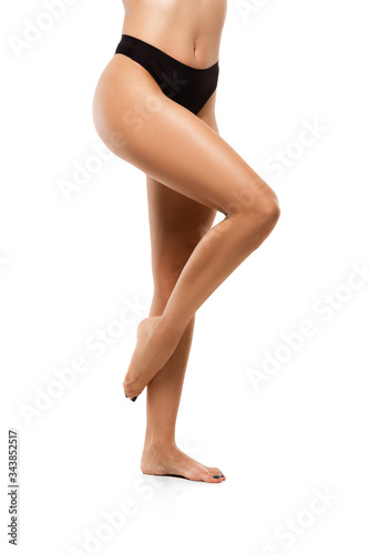 Beautiful female legs, buttlocks and belly isolated on white background. Beauty, cosmetics, spa, depilation, treatment and fitness concept. Sportive, sensual body with well-kept skin in underwear.