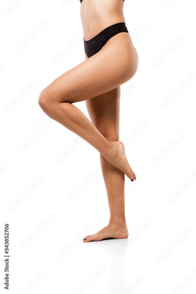 Beautiful female legs, buttlocks and belly isolated on white background. Beauty, cosmetics, spa, depilation, treatment and fitness concept. Sportive, sensual body with well-kept skin in underwear.