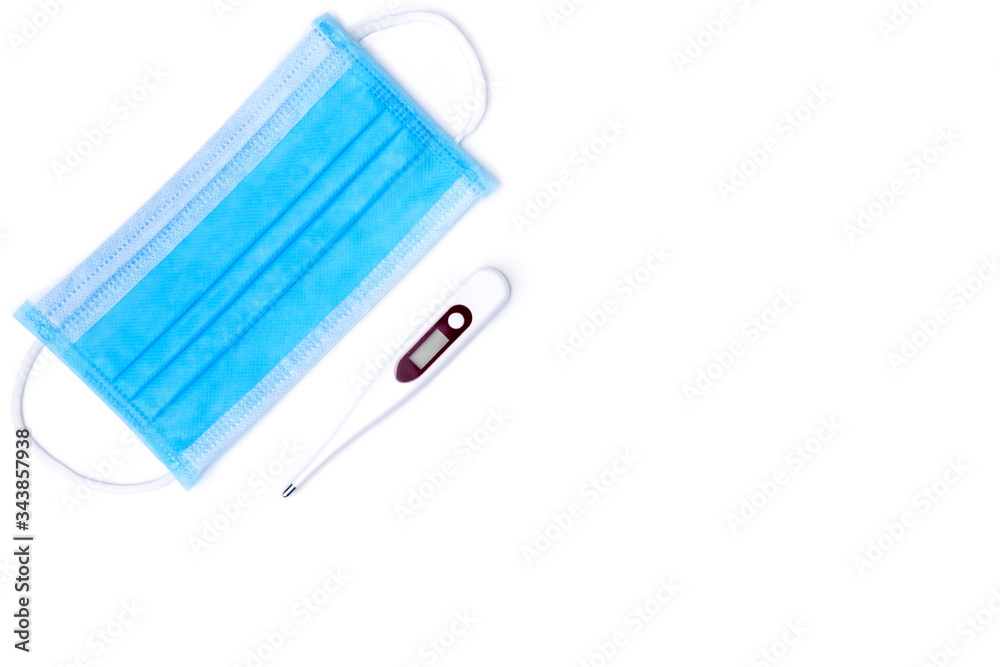 blue face mask and digital thermometer isolated on white background. face mask is equipment for prevent virus or air pollution. thermometer is used for diagnosis health such as fever or cold blue face mask and digital thermometer isolated on white background. face mask is equipment for prevent virus or air pollution. thermometer is used for diagnosis health such as fever or cold