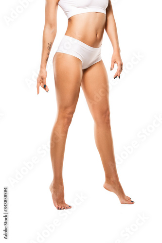 Beautiful female legs and belly isolated on white background. Beauty, cosmetics, spa, depilation, treatment and fitness concept. Fit and sportive, sensual body with well-kept skin in underwear.