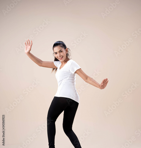 Young beautiful woman standing feet aparts,raise handsup in the air,little twisted,dance workout for exercise,with happy feeling © Watcharin