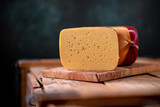 Medium hard cheese gouda edam on wooden board on sunlight table traditional table texture