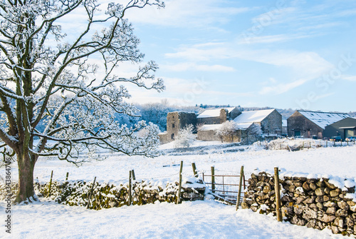 Foto Beetham Hall on a snowey Winters day with dry stone wall and gate in foreground
