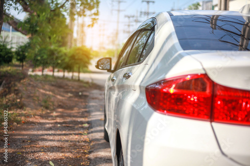 White cars parked on the roadside, with natural backgrounds and with bright sunlight.