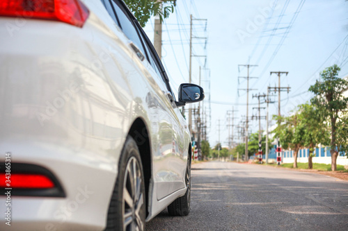 White cars parked on the roadside, with natural backgrounds and with bright sunlight.