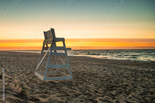 An empty lifeguard stand looks out over the ocean at sunrise at Beach Haven, NJ