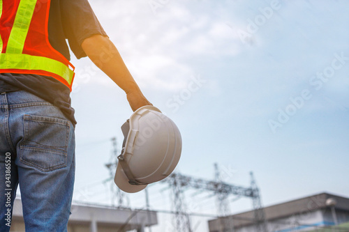 Close-up Engineering holds white safety hats on hight Electric volteage background