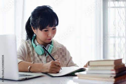 Asian woman writing on the ...