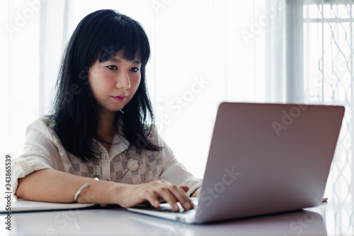 Asian woman using laptop an...