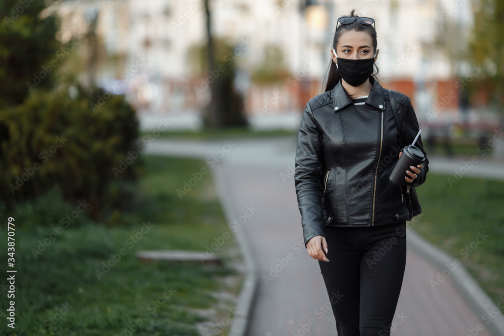A masked girl is walking along the street. Coronavirus infection COVID-19 A masked girl is walking along the street. Coronavirus infection COVID-19