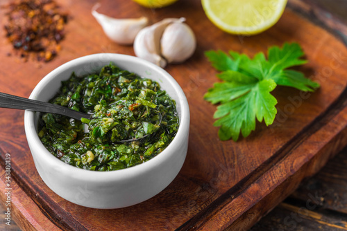 Traditional Argentinian chimichurri sauce against wooden backgroundv