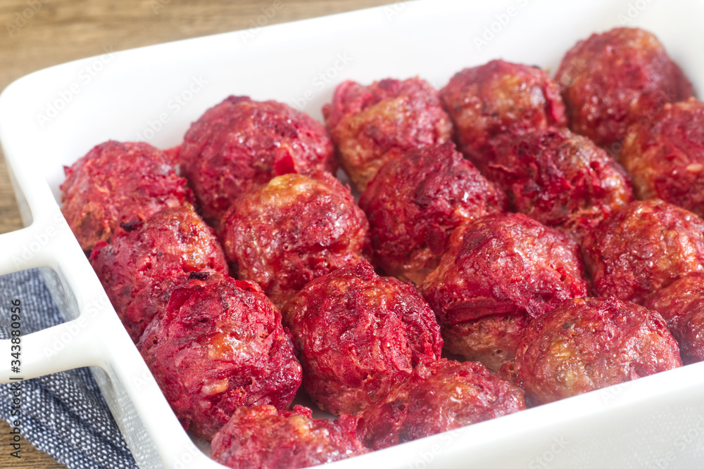 Homemade red meetballs in the white pan.