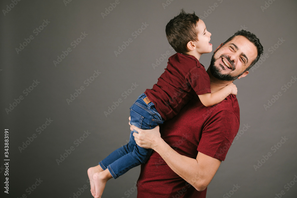 Obraz premium Portrait of a father and son playing in studio