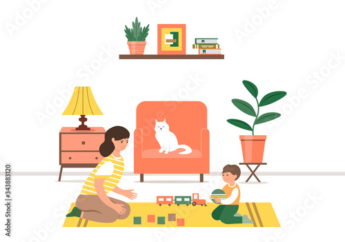 Happy family. Loving mom and cheerful baby spend free time together. Mother and little son play toys sitting on the floor in the room.