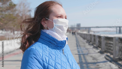 A girl in a protective mask on the street. Prevention and protection of health and safety of life.
