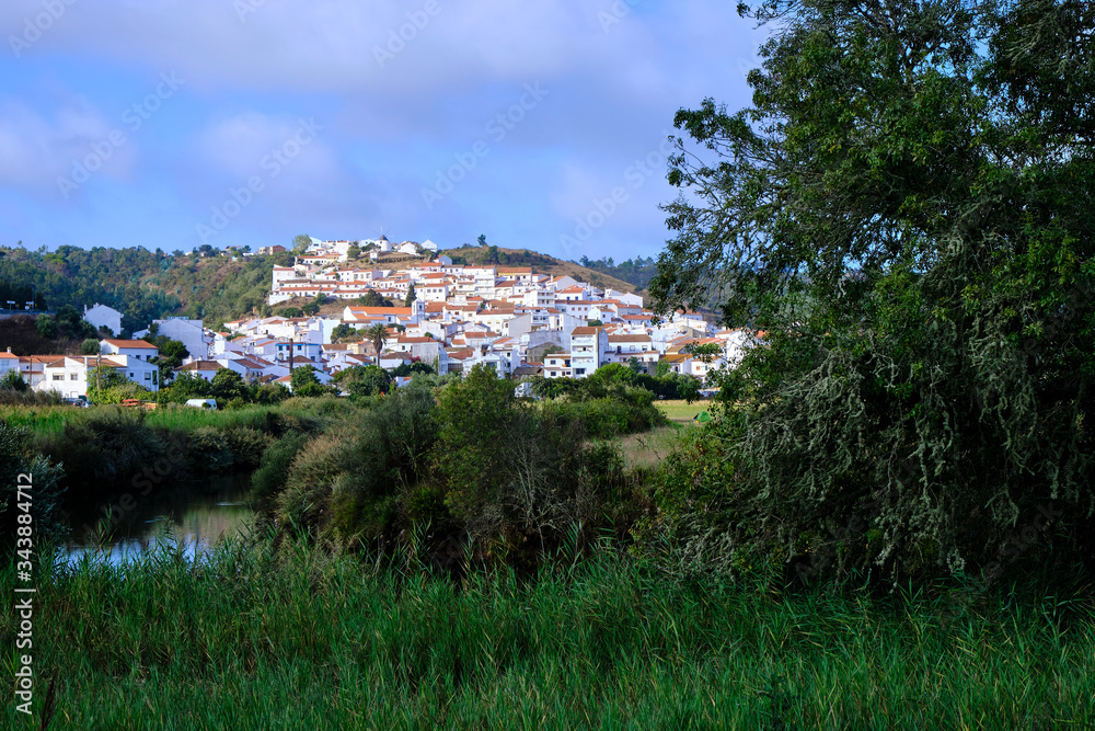 The village of Odeceixe in the morning light. Solo Backpacker Trekking on the Rota Vicentina and Fishermen's Trail in Algarve, Portugal. Walking between cliff, ocean, nature and beach.